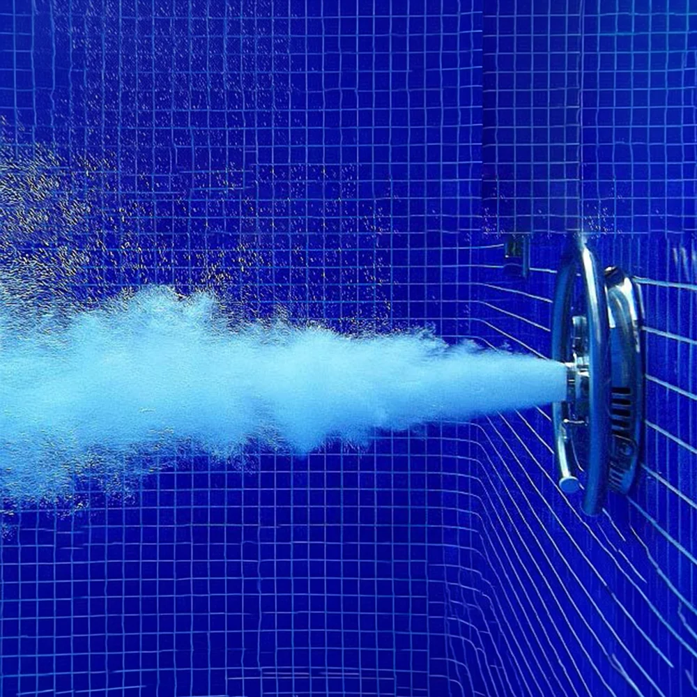 Counter-current swim jet firing across a blue mosaic-tiled pool wall
