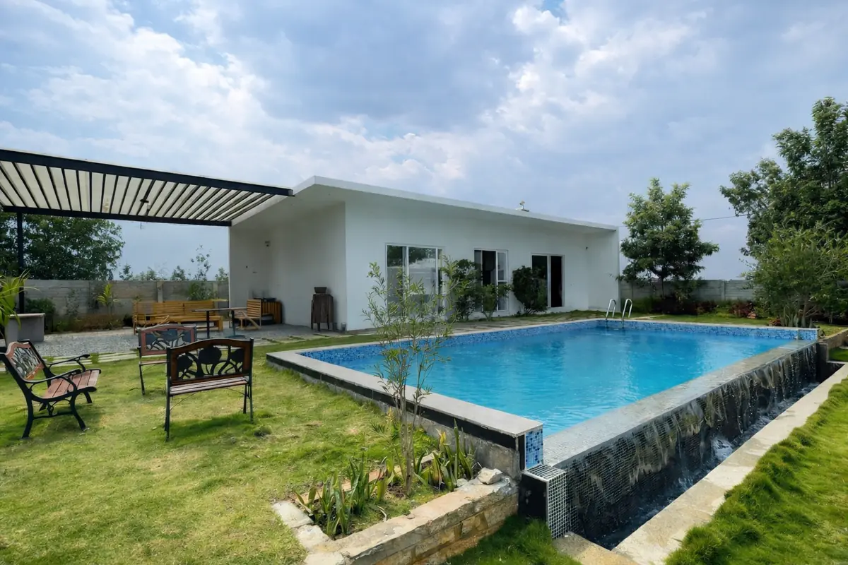 Raised pool with stone cladding beside the house at Adnan Farm House