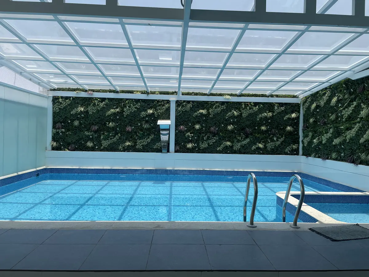Covered pool with a living green wall and skylight roof at Srinivas Residence
